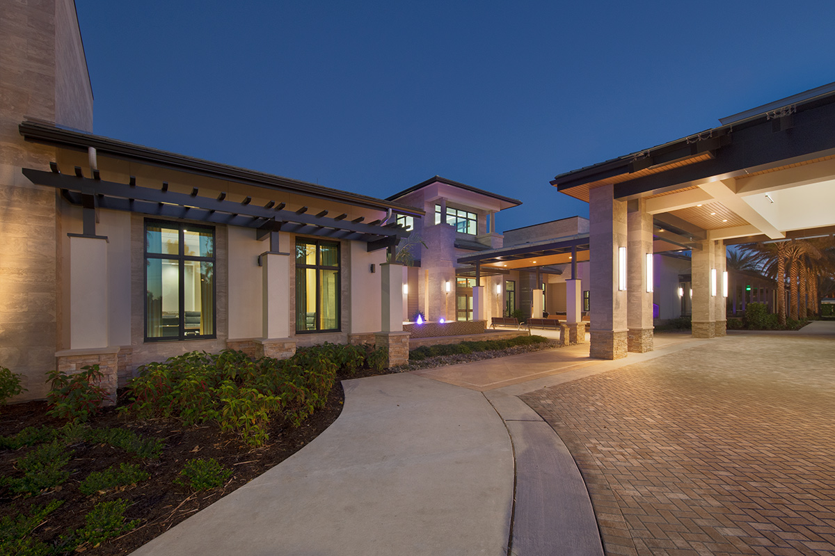 Architectural dusk view of Moorings Park Clubhouse entrance in Naples, FL