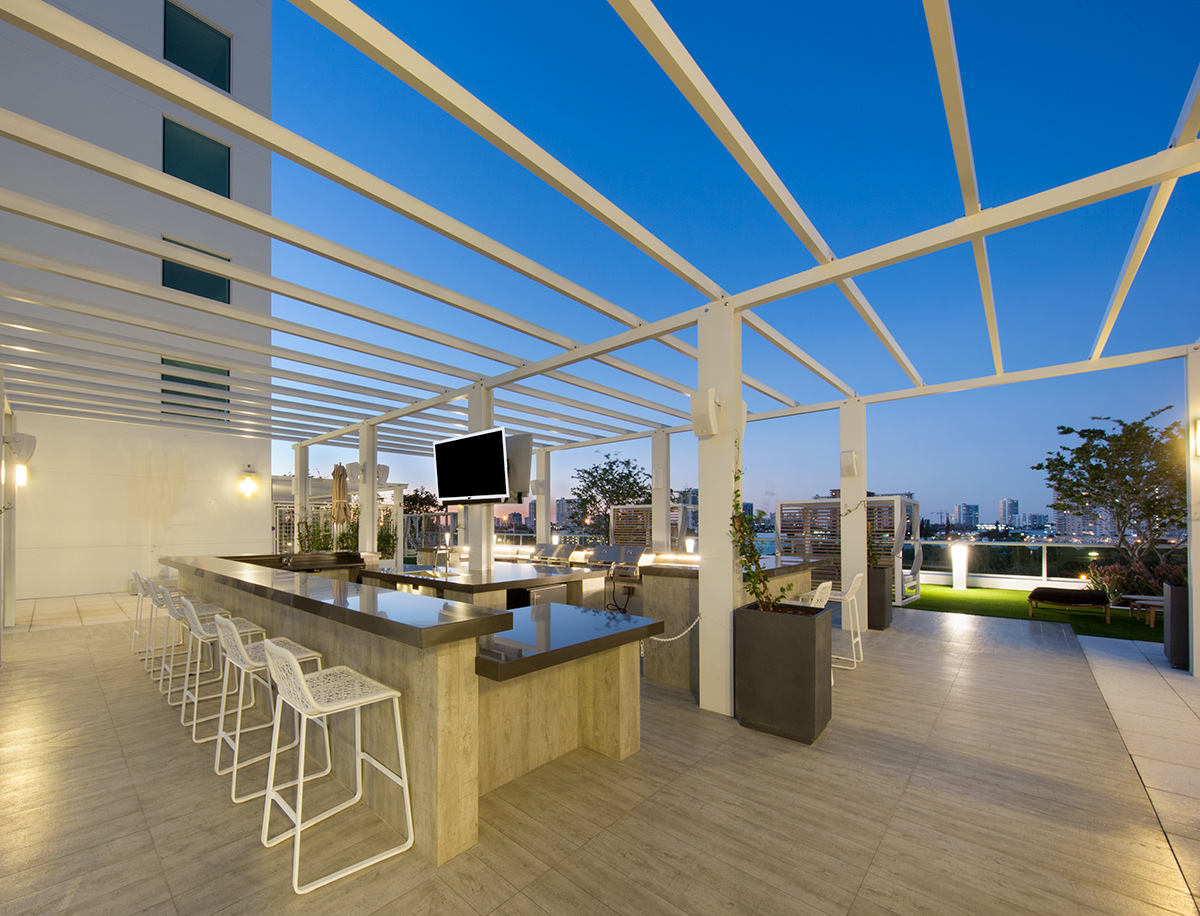 Architectiural dusk view of the pool deck bar at the 400 Sunny Isles condo.