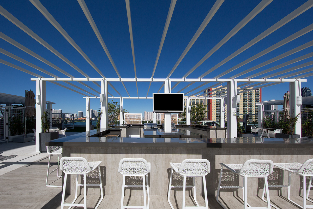 Architectiural dusk view of the pool deck bar at the 400 Sunny Isles condo.